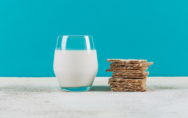 Set of waffles and glass of milk on a blue background. top view.