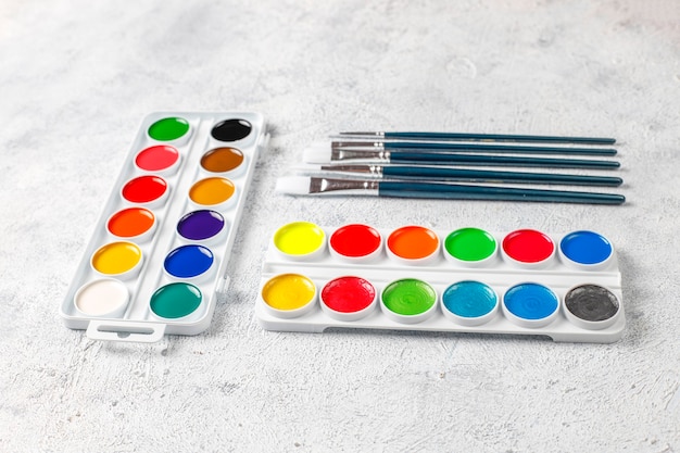 Free photo set of watercolor paints and paintbrushes for painting.