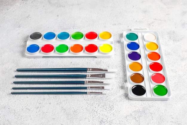 Set of watercolor paints and paintbrushes for painting.