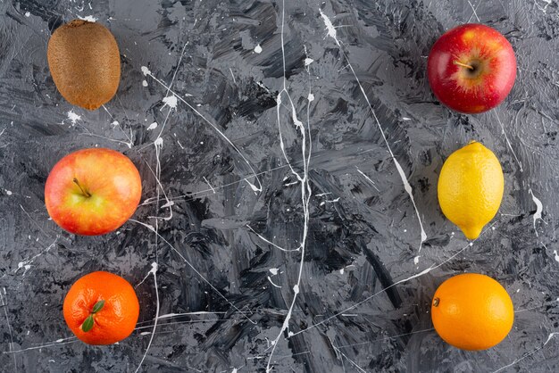 Set of whole delicious organic fruits on marble surface.