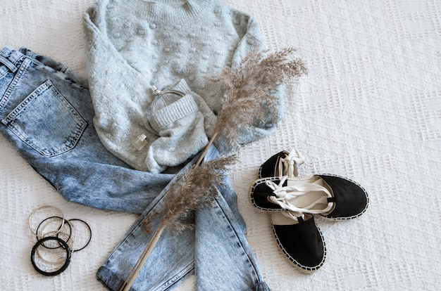 Set with fashionable women's clothing jeans and sweater, shoes and accessories, flat lay.