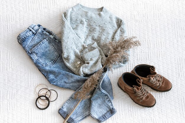 Set with fashionable women's clothing jeans and sweater, shoes and accessories, flat lay.