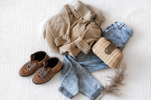 Set with fashionable women's clothing jeans and sweater, shoes and accessories, flat lay.