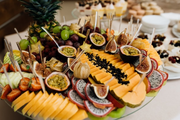 Set with variety of exotic fruits, cutted on the plate, banquet buffet