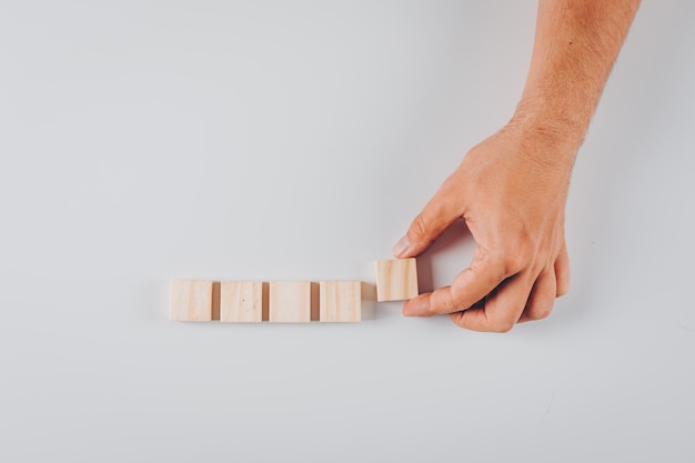 Set of wooden blocks and man holding wooden block on white