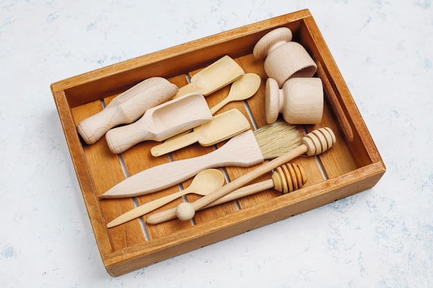 Set of wooden kitchen utensils on concrete surface