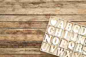 Free photo a set of wooden letters in a wooden box top view