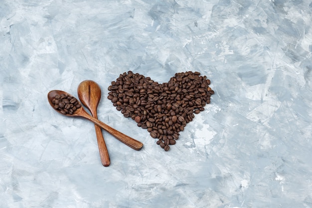 나무 숟가락과 회색 석고 배경에 커피 콩의 집합입니다. 평평한 평신도.