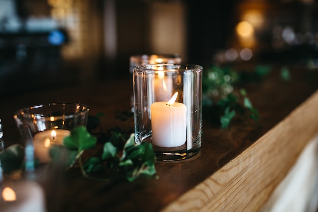 Several candles stand on wooden shelf