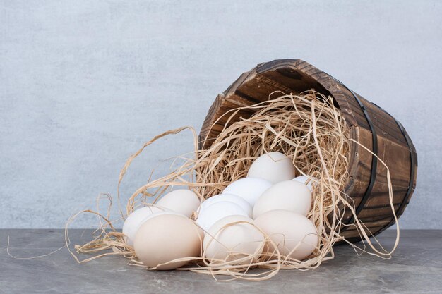 Several chicken fresh eggs on hay on marble background. High quality photo