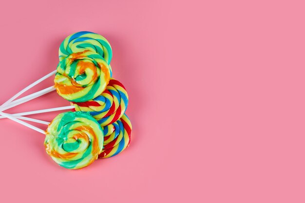 Several colorful lollipops on pink background.