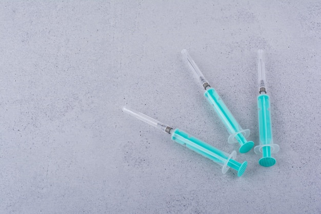 Several empty syringes on marble background. High quality photo