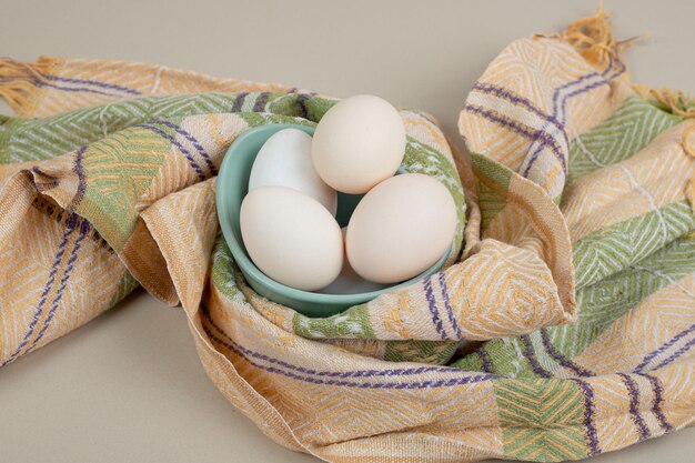 テーブルクロスにいくつかの新鮮な鶏の白い卵。