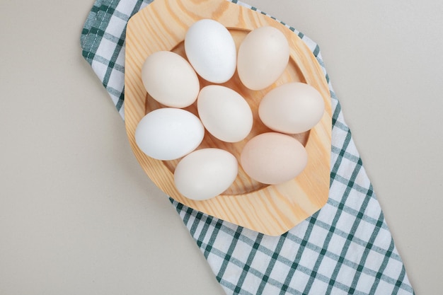 나무 접시에 몇 가지 신선한 닭고기 흰 계란.
