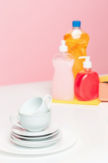 Several plates, a kitchen sponge and a plastic bottles with natural dishwashing liquid soap