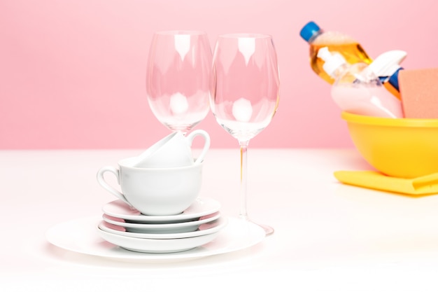 Several plates, a kitchen sponges and a plastic bottles with natural dishwashing liquid soap in use for hand dishwashing.