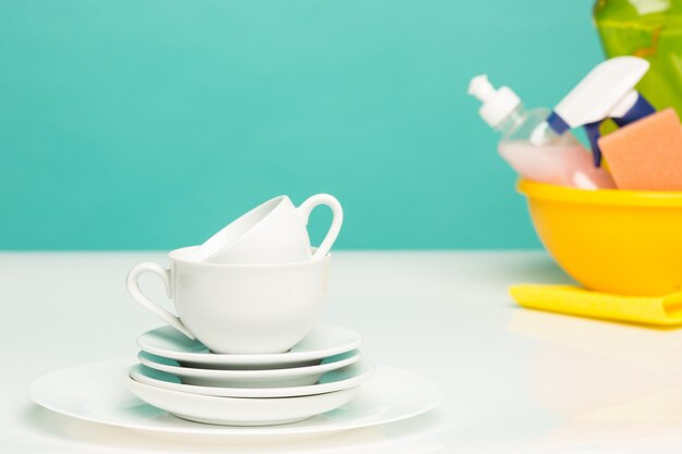 Several plates, a kitchen sponges and a plastic bottles with natural dishwashing liquid soap