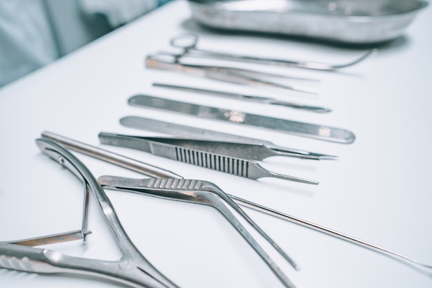 Several surgical instruments lie on a white table