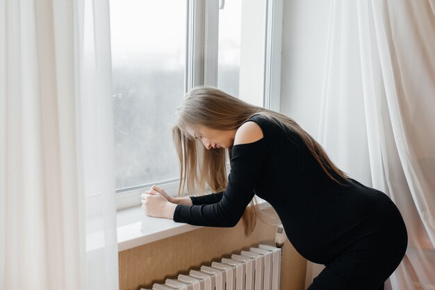 premium-photo-severe-pain-in-a-pregnant-woman-standing-near-the