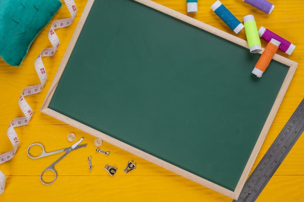 A sewing kit, needle, thread, a needle, placed on a yellow wooden floor.