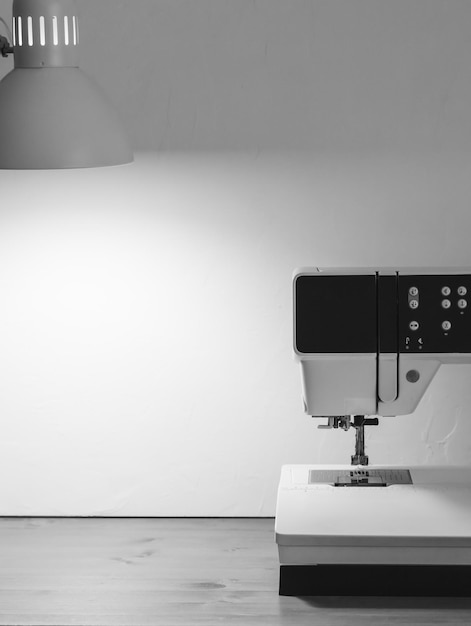 Sewing machine on a work desk black and white photo white background Premium Photo
