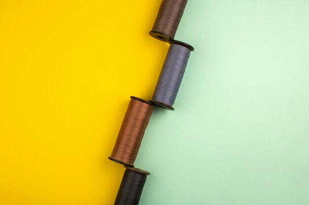 Sewing threads colored on a yellow and green background