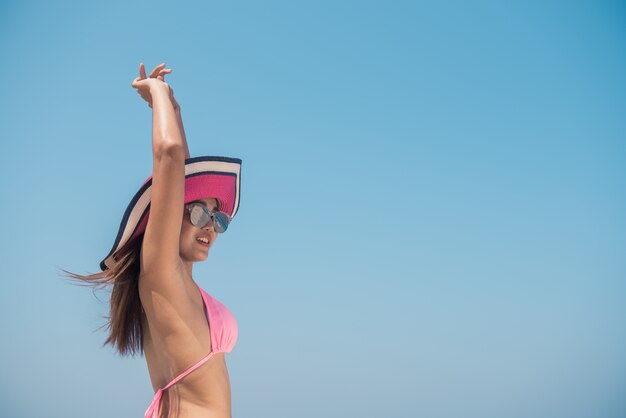 Сексуальная бикини тела Азии женщина игривая на пляже тропический пляж, с удовольствием играет брызг воды в свободе с распростертыми объятиями. Красивая девушка для тела в путешествии. Обрезка баннеров для копирования.