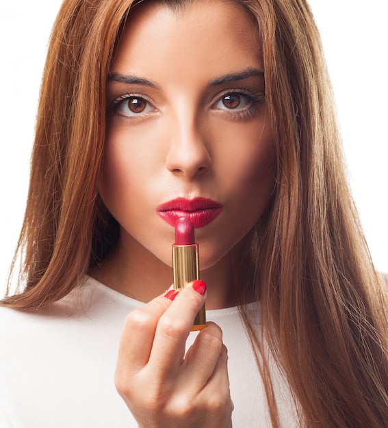 Foto gratuita sexy brunette applicare il rossetto rosso.