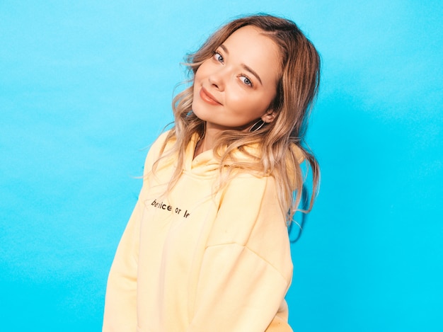 Free photo sexy carefree woman posing near blue wall. positive model having fun