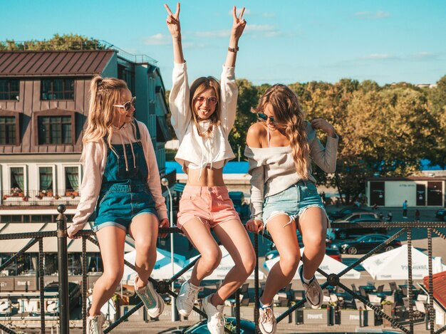 Sexy carefree women sitting on handrail the street They raising hands