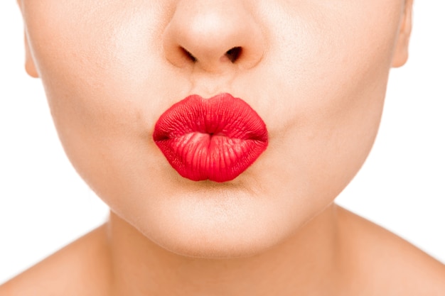 Сексуальные губы. Красота красная деталь макияжа губ. Поцелуй. Женское лицо крупным планом
