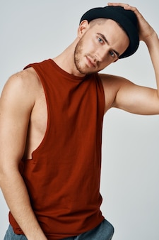Сексуальный мужчина в красной футболке позирует moda studio изолированный фон