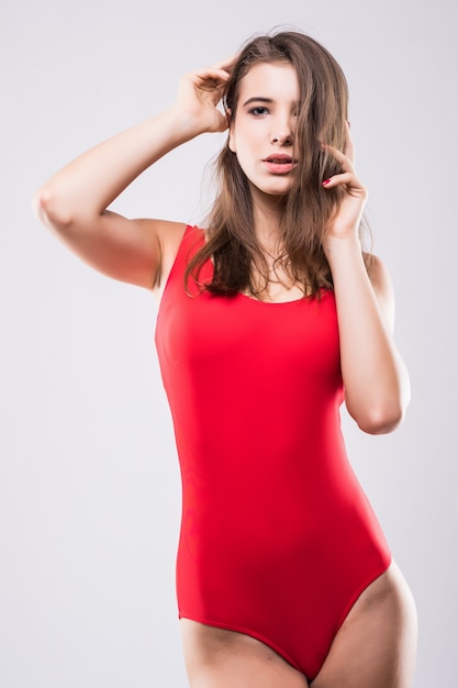 Сексуальная модель девушка в красном плавательном люксе, изолированные на белом фоне