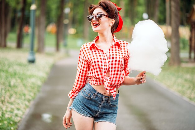 手でロリポップのセクシーなピンナップガールは 公園 レトロなアメリカンファッションで歩きます ピンナップスタイルで魅力的な女性 プレミアム写真