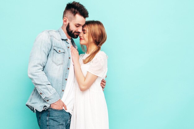 Sexy smiling beautiful woman and her handsome boyfriend Happy cheerful family having tender moments near blue wall in studioPure cheerful models huggingEmbracing each other Cheerful and happy