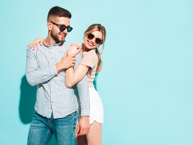 Sexy smiling beautiful woman and her handsome boyfriend Happy cheerful family having tender moments near blue wall in studioPure cheerful models huggingEmbracing each other