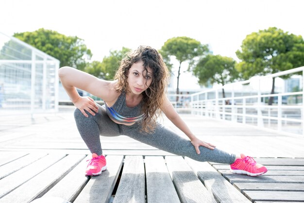 Sexy Sporty Woman Stretching Leg on City Bridge