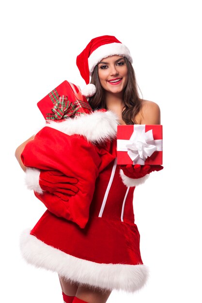 Sexy woman giving christmas gifts from sack of santa claus