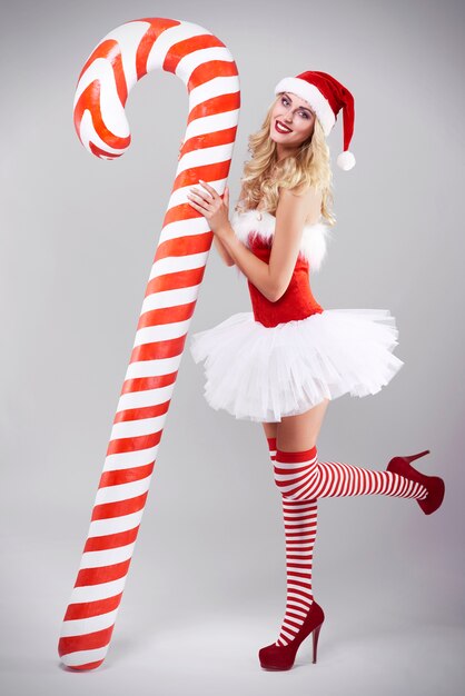 Sexy woman in santa costume on grey wall