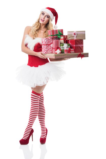 Sexy woman in santa costume posing on white wall