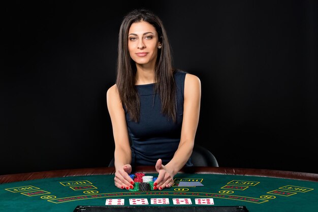 Сексуальная женщина с покерными картами и фишками. Игрок в красивом черном платье