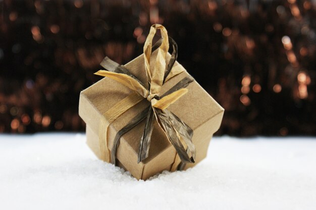 Потертый шикарный рождественский подарок, расположенный в снегу