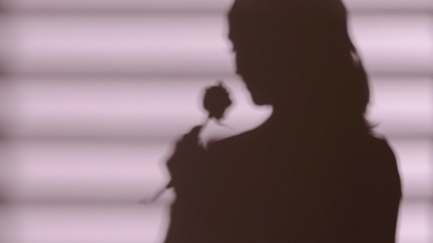Free photo shadow of woman holding a rose