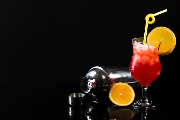 Foto gratuita agitatore e bicchiere di cocktail con copia spazio e arancio