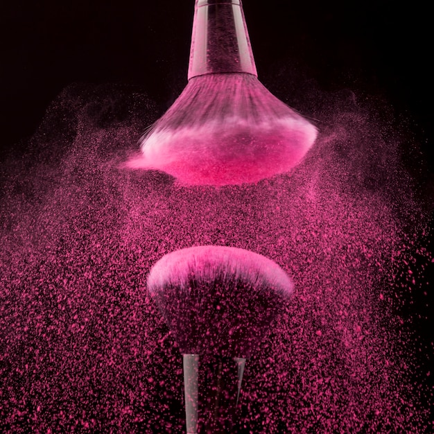 Free photo shaking brushes with bright pink powder