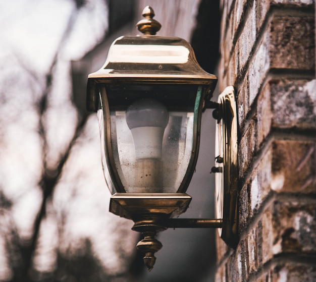 Free photo shallow closeup shot of a street lantern on a stone wall