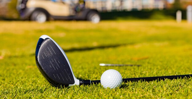 ゴルフクラブと芝生の上のボールの浅い焦点