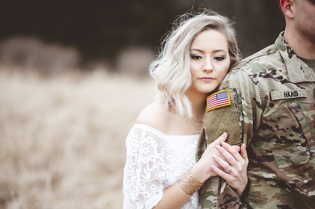 미국 군인의 팔을 들고 매력적인 여성의 얕은 초점 샷