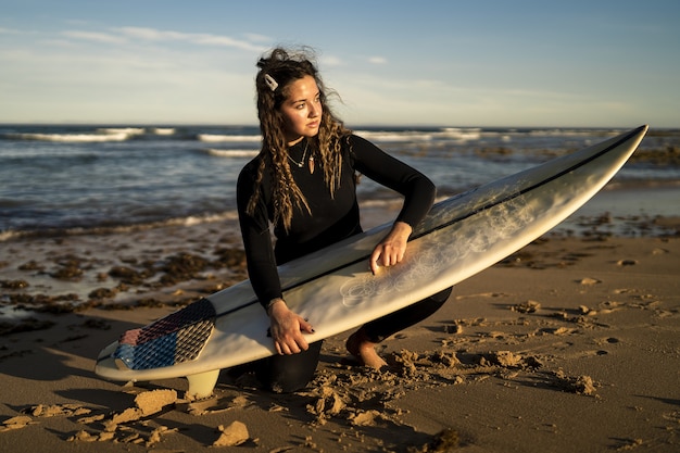 스페인 해변에서 그녀의 서핑 보드 왁싱 매력적인 여성의 얕은 초점 샷
