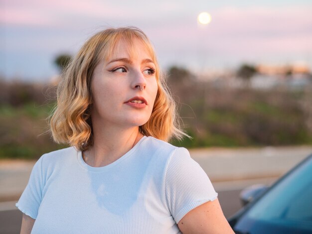 Shallow focus shot of a beautiful blonde caucasian female with a white shirt looking right